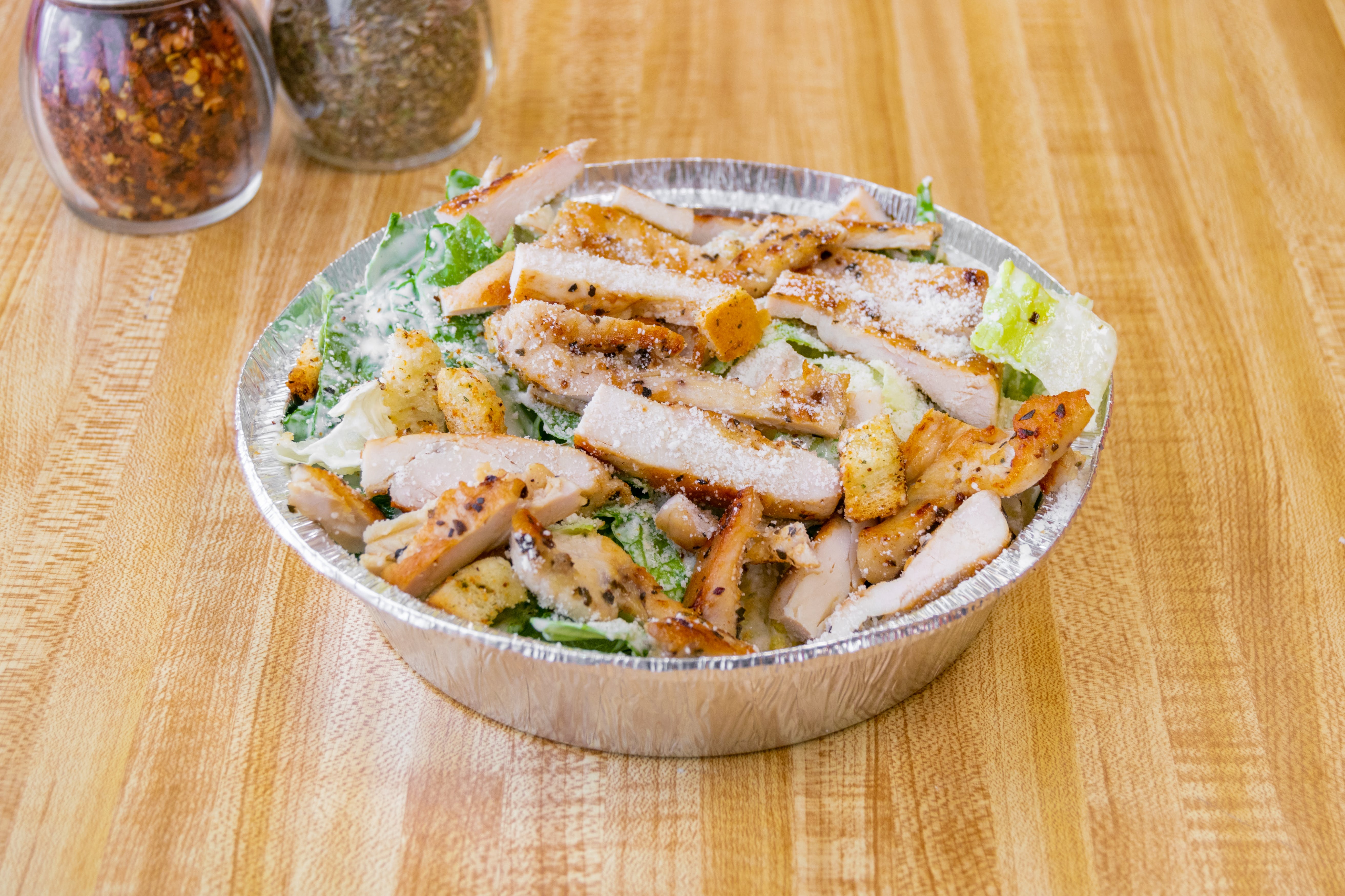 https://slicelife.imgix.net/12042/photos/original/QueenPizzaDeli_GrilledChickenCaesarSalad.jpg?auto=compress&auto=format